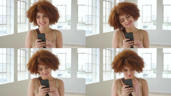 时尚的红发女人在手机上阅读浪漫的短信。一位时尚时尚的女性在使用社交媒体时微笑着思考。体贴的年轻女孩使