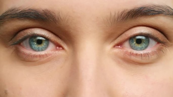 用视觉、视觉和焦点缩放女人脸上的眼睛、睫毛和眉毛。一位女性的肖像，在思考，凝视和用蓝眼睛看着前方时眨