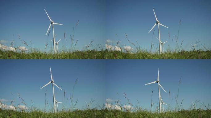 风力涡轮机旋转并产生可持续生态能源的地面射击。风车在绿色领域生产清洁可再生能源。背景与美丽晴朗的夏天