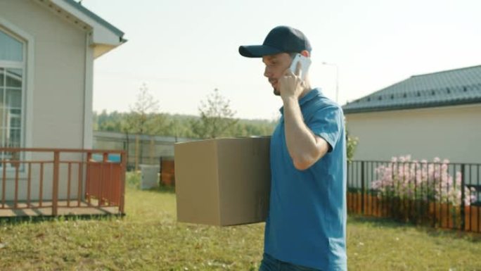 郊区带包裹的送货员在手机上说话的慢动作