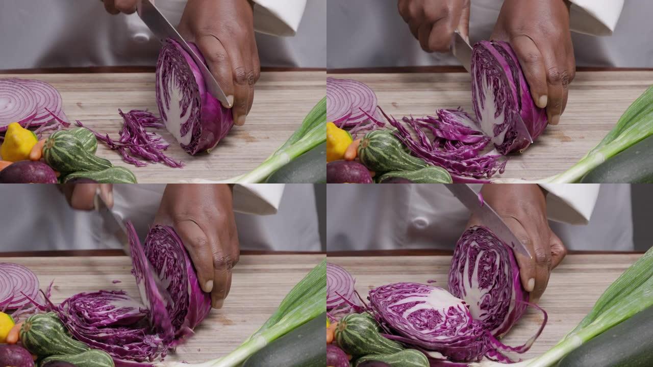 非洲黑人厨师的双手在被其他蔬菜包围的砧板上切白菜的短视