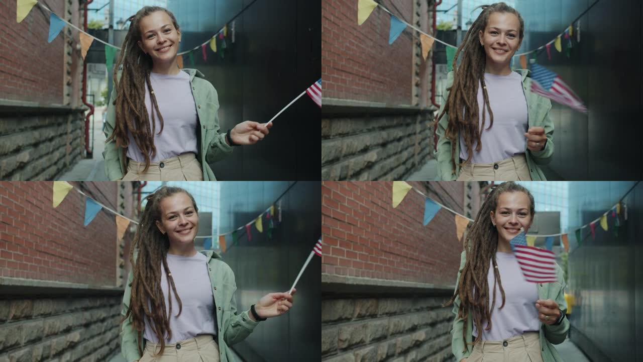 这是一幅可爱的女学生的肖像，她留着长发绺，站在外面挥舞着美国国旗，微笑着看着镜头
