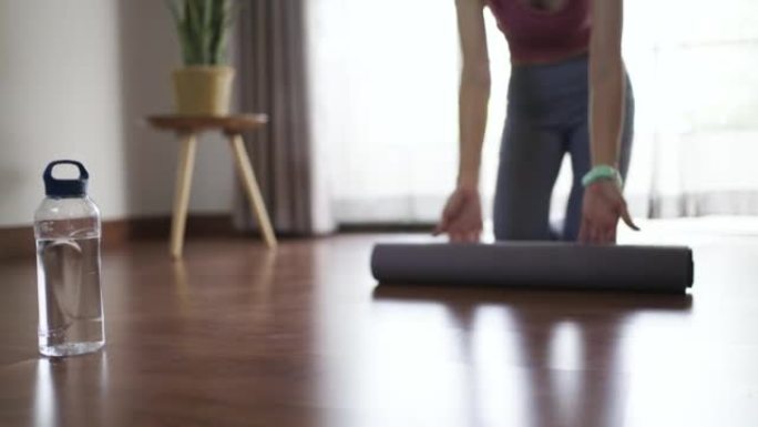 运动女人打开垫子开始在家做瑜伽锻炼