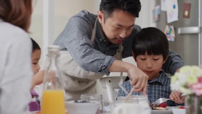 快乐的亚洲家庭早餐吃煎饼孩子们周末早上在厨房和父母一起享受健康的自制餐4k镜头
