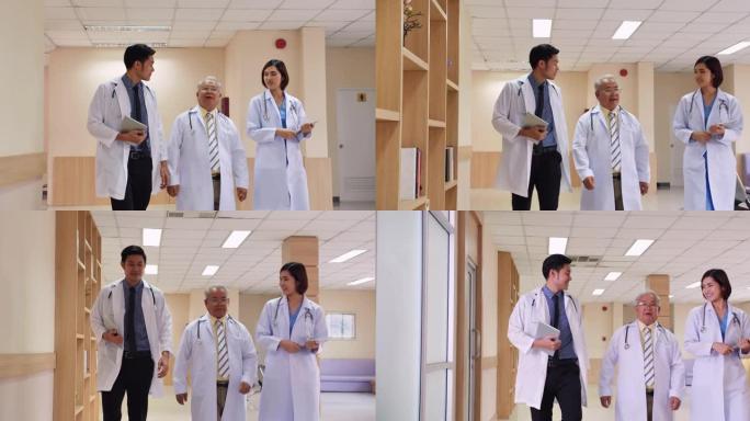亚洲资深男性医学教授走过医院走廊，向现代医院大楼的医疗团队谈论患者的健康。医院概念。