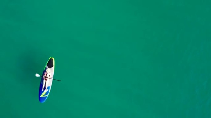 蓝色泻湖中的空中女子划桨