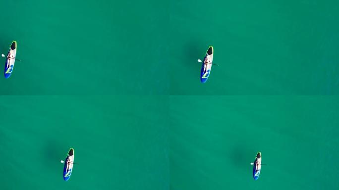 蓝色泻湖中的空中女子划桨