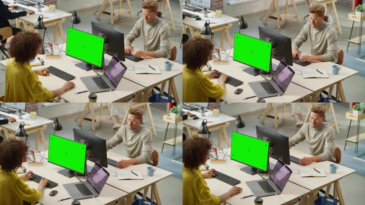 在现代办公室从事计算机工作的各种富有创造力的同事。混血儿女人使用绿色色度键屏幕监视器。白人男性图形设
