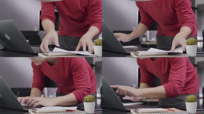 特写镜头有吸引力的亚洲男子企业家打开笔记本电脑，并在早上在家工作时开始从事他的创新项目。他正在使用笔