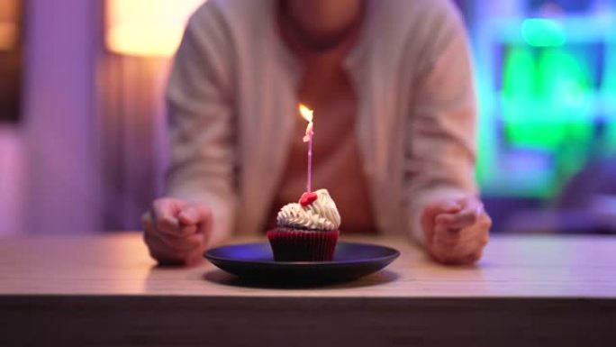 女人在蛋糕上吹蜡烛