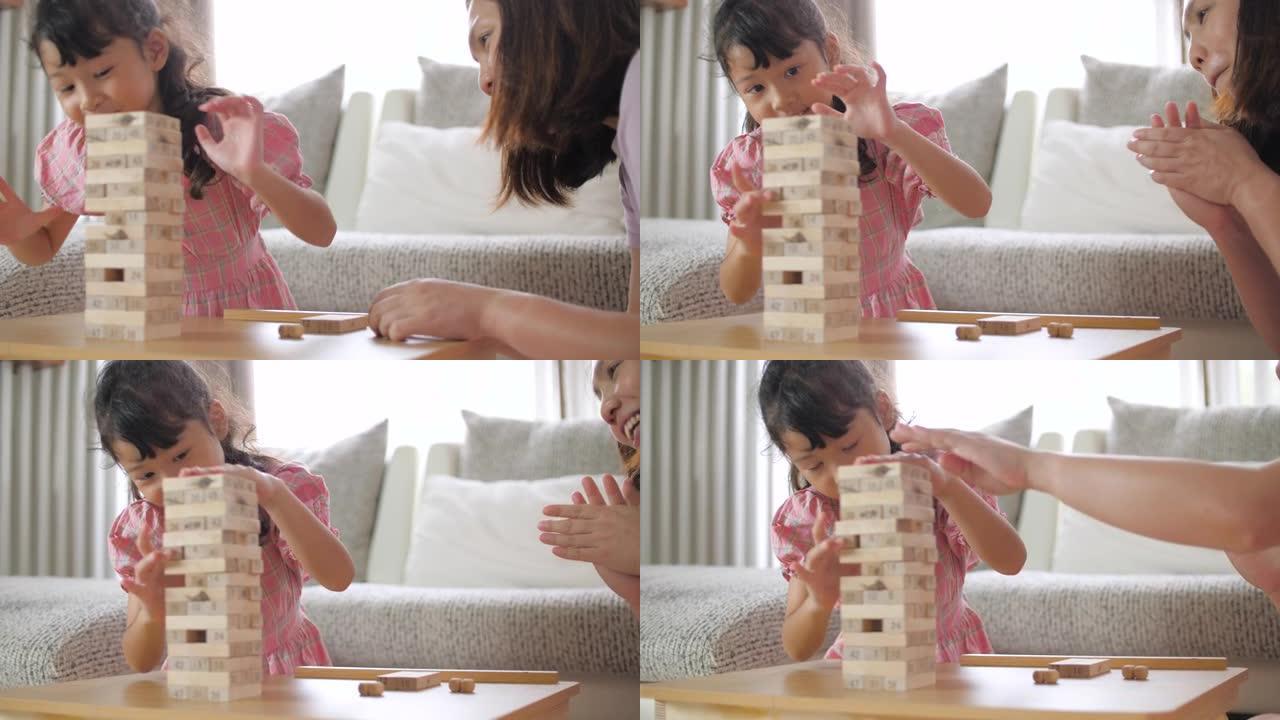 小女孩在家里的客厅里和母亲一起建造木块