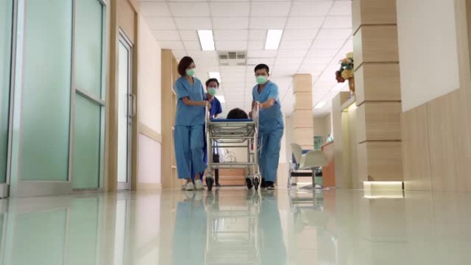 4K UHD缩小视角低角度拍摄: 医疗团队将医院格尼担架床上的患者运送到医院走廊。