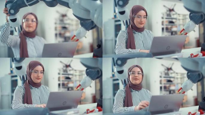 Hijab的中东工程师在Modern Office的笔记本电脑上对机械臂和编程进行了深入分析。优化自