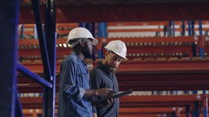 两名男子在建筑工地一起工作时使用数字平板电脑进行讨论的4k录像