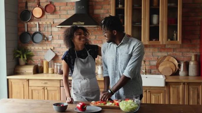 爱浪漫的情侣在舒适的厨房一起烹饪蔬菜沙拉