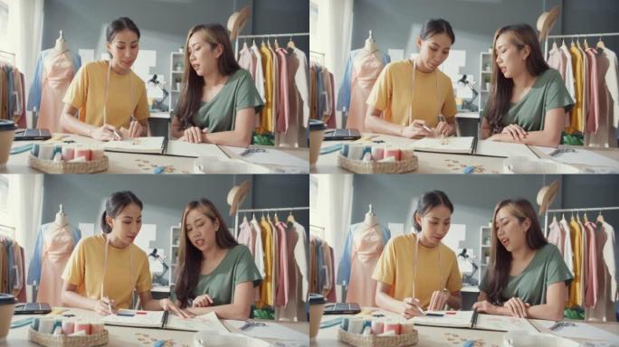 两位专业的亚洲开朗的女士设计师团队合作，在新时尚系列上进行休闲会议素描本工作，讨论商店中的色彩分享想