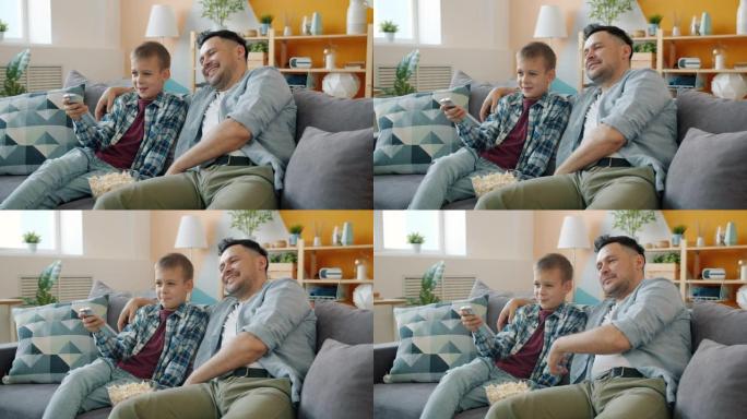 小男孩在家看电视，有爱心的爸爸坐在客厅的沙发上聊天