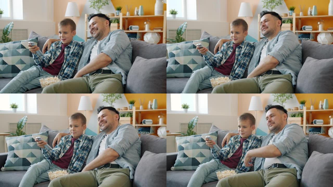 小男孩在家看电视，有爱心的爸爸坐在客厅的沙发上聊天