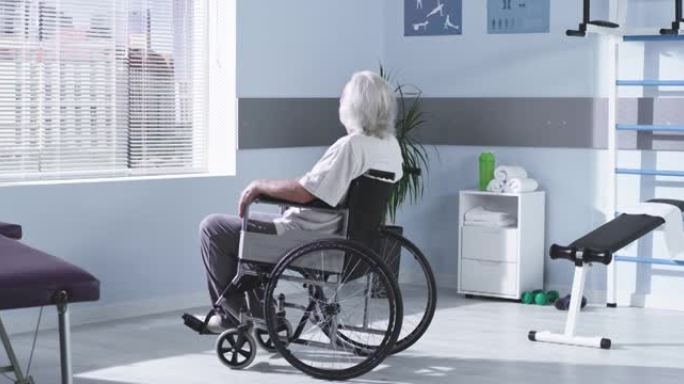 轮椅上的残障老人望着窗外