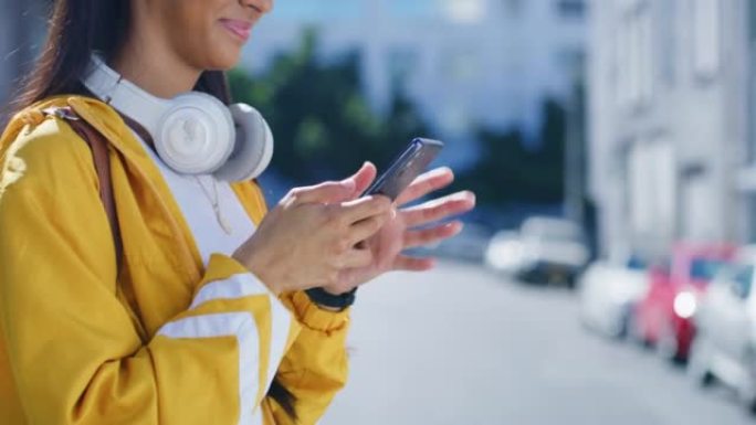 在城市中，时髦的女人用电话用脖子上的无线耳机发送短信。一名女性使用GPS定位应用程序或地图查找前往下
