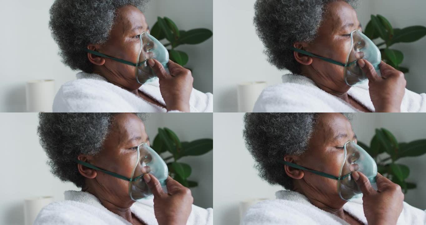 非裔美国高级妇女在家中使用氧气面罩呼吸