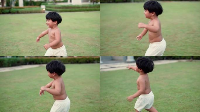 可爱的蹒跚学步的小男孩在乡村公园绿草丛中奔跑