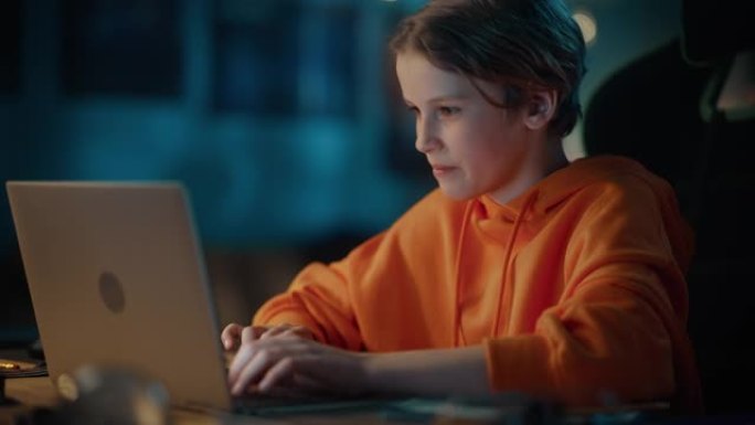 聪明的小男孩在家里黑暗舒适的房间里使用笔记本电脑。快乐的青少年在线浏览教育研究，在社交媒体上与朋友聊