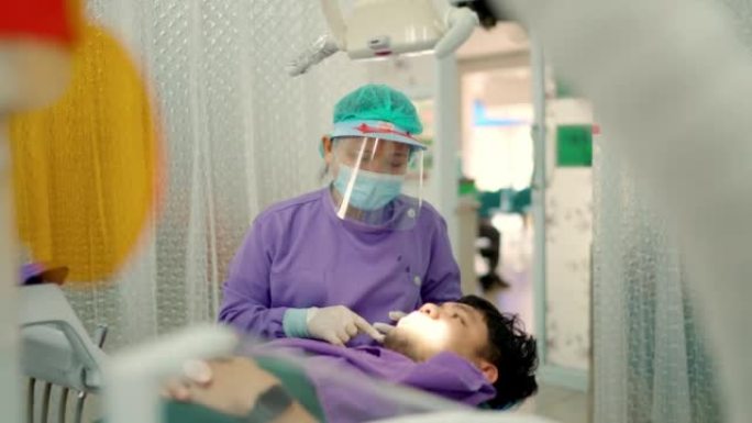 在牙科诊所治疗病人的女牙医。