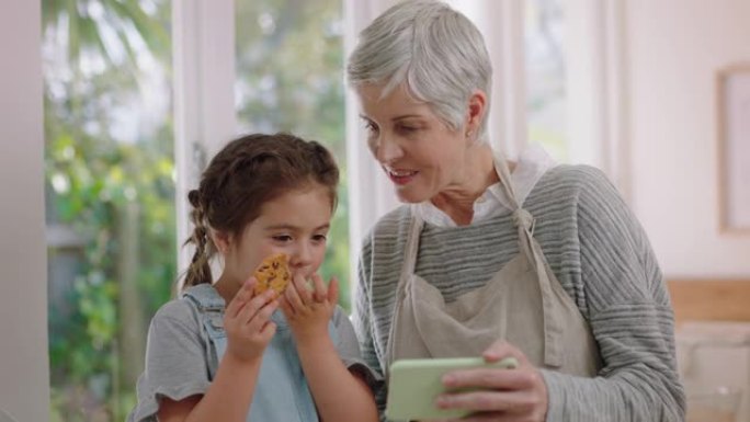 祖母和孩子使用智能手机进行视频聊天小女孩分享假期周末显示饼干奶奶喜欢在家和孙女在手机上聊天