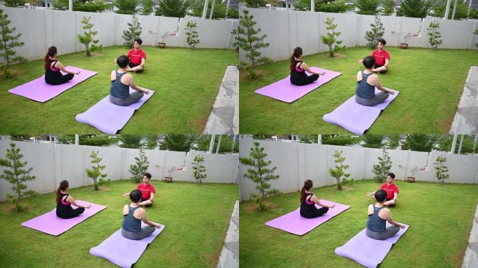 亚洲中国中年妇女与朋友一起练习瑜伽前院
