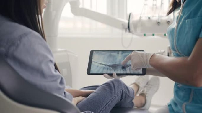 MS牙医使用数字平板电脑向女性患者显示x射线