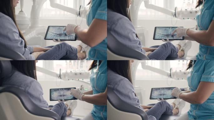 MS牙医使用数字平板电脑向女性患者显示x射线
