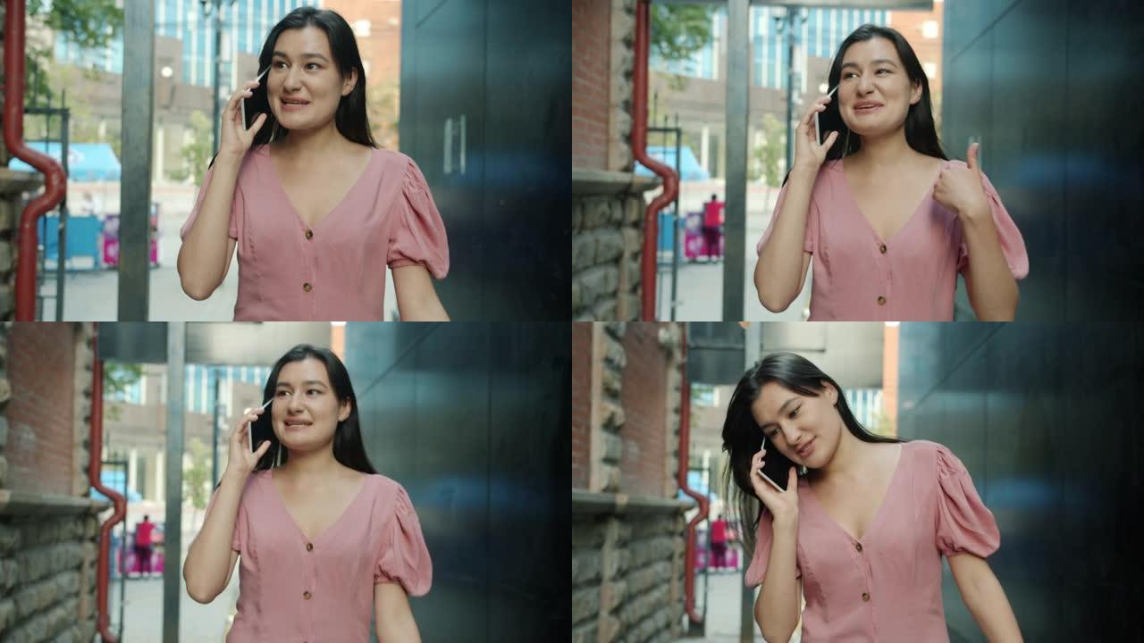 多莉拍摄的美丽的亚洲女人在户外散步在手机上说话，在户外微笑