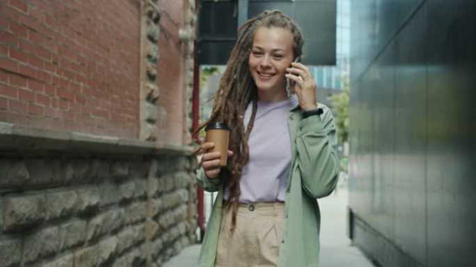 有恐惧的可爱女孩慢动作在手机上聊天喝酒去咖啡在外面散步