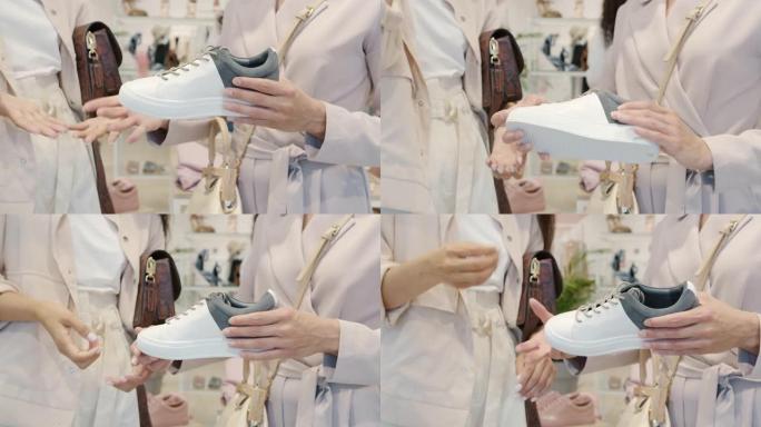 女人在鞋店与朋友交谈时，女性双手握着时髦的鞋子并打手势的特写镜头