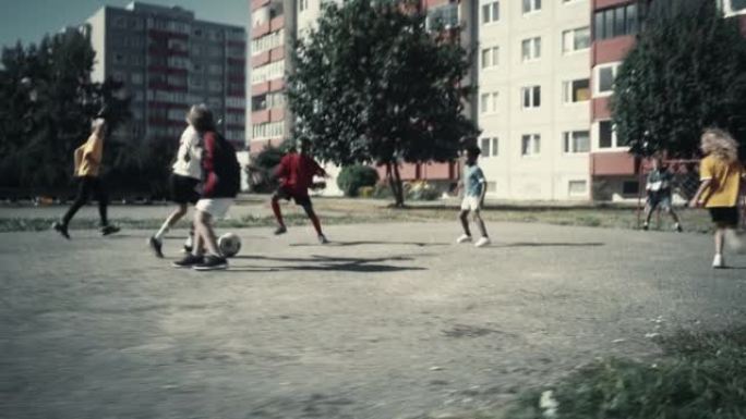 快乐的多元文化朋友在夏天阳光明媚的日子在后院踢足球。欢快的男孩和女孩庆祝进球并赢得比赛。冷色分级。