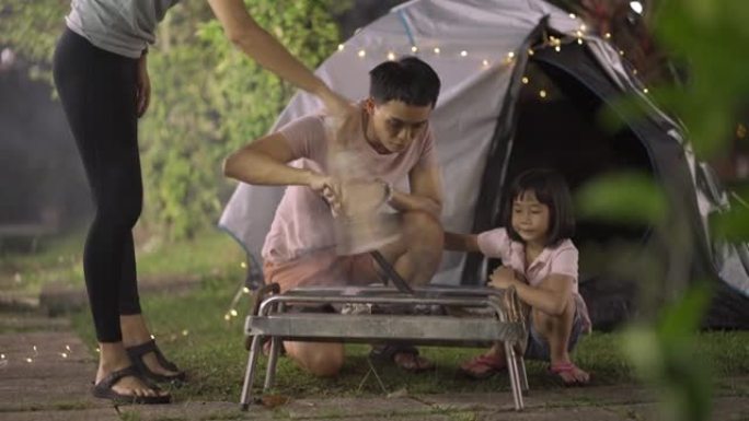 亚洲华人家庭在他们的房屋后院建立消防露营周末活动