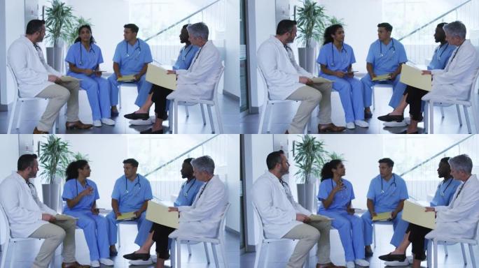 多元化的男女医生在医院员工会议上坐着讨论