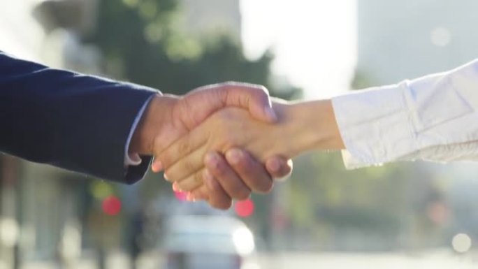 商界人士在城市街道上就b2b交易或问候握手。公司经理或领导的特写镜头欢迎入职公司员工在户外握手。