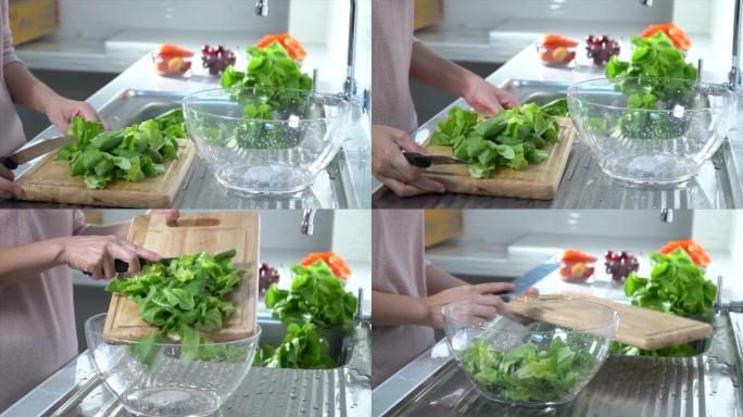 女人在厨房水槽中切碎新鲜生菜的特写镜头: 健康的生活方式理念