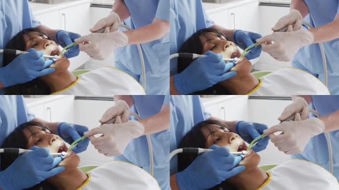 在现代牙科诊所检查女性患者牙齿的男性牙医和牙科护士的手