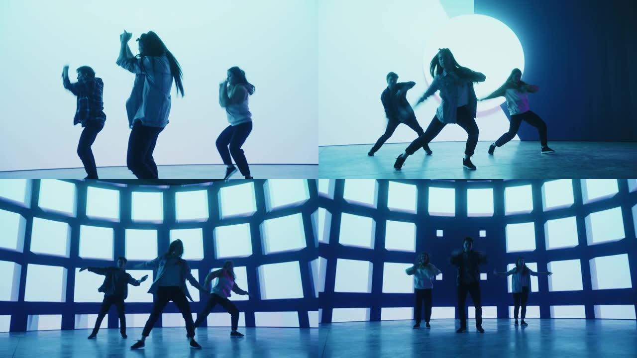 由三名专业舞者组成的多元化小组，在工作室环境中的虚拟制作期间，在带有蓝色VFX动画的大Led墙屏幕前