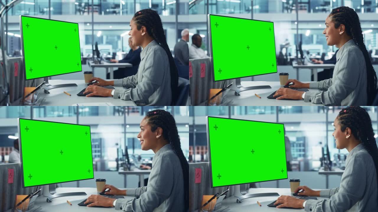 多样化的公司办公室: 美丽的黑人女性信息技术人员使用带有绿色色度键屏幕的台式计算机。创意软件工程师从