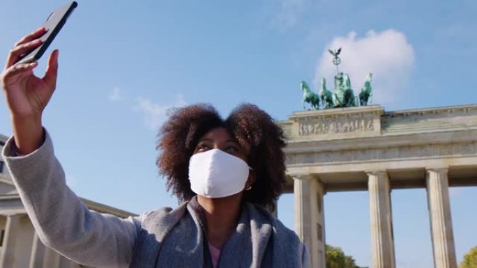 女人在柏林的勃兰登堡门前打视频电话