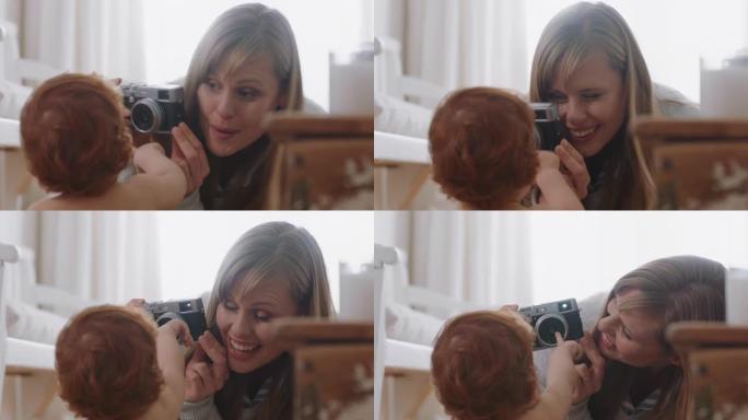 快乐的母亲用相机拍摄婴儿照片兴奋的妈妈拍摄可爱的幼儿享受母亲的生活方式制作回忆