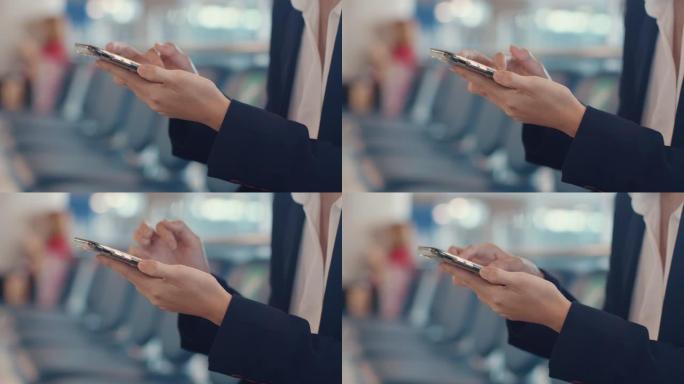特写亚洲商务女士旅行者穿西装坐在长凳上使用智能手机预订机票在机场等待航班。