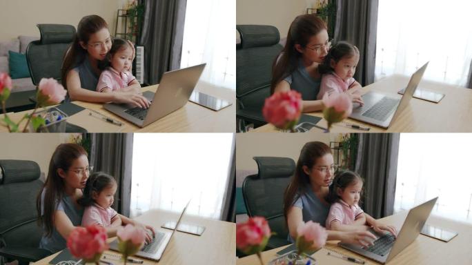 母亲Python开发人员使用笔记本电脑远程编码在家工作并照顾女儿