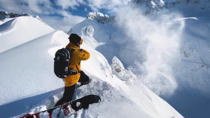 在一个阳光明媚的冬日，滑雪者站在白雪皑皑的山脊上，向空中扔雪