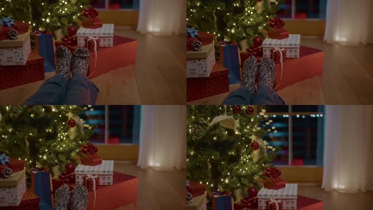 TU面目全非的人坐在地板上，旁边是圣诞树