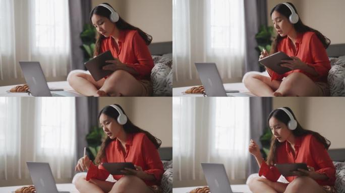亚洲女人在卧室用笔记本电脑进行视频会议聊天